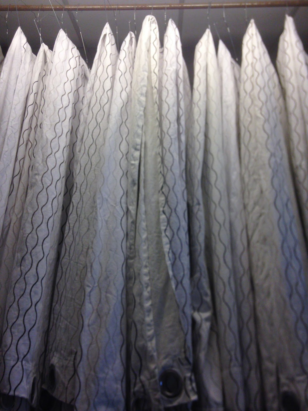 Visillos y cortinas limpios y planchados, colgados en el taller de la lavandería Vite Propre de Burdeos